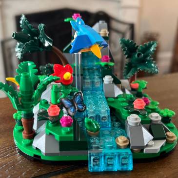 a photograph of a nearly complete Lego set depicting a rainforest waterfall scene--and a small blue bird